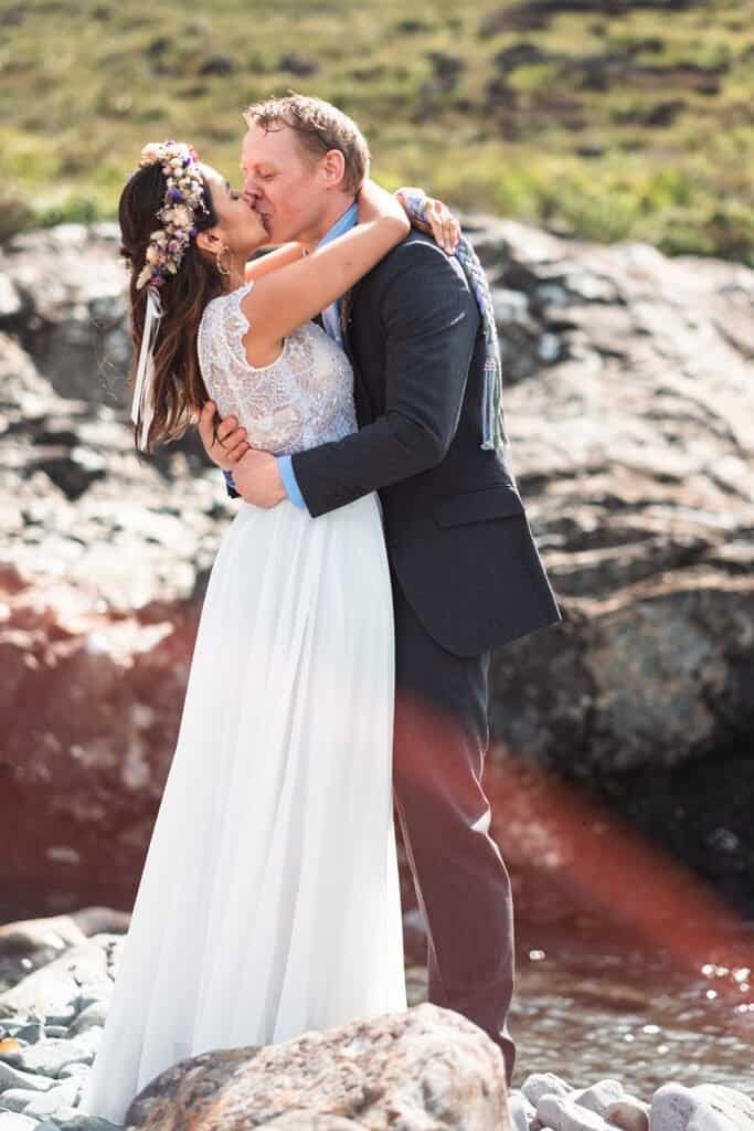 Bride and groom embrace in stunning waterfall in Isle of Skye