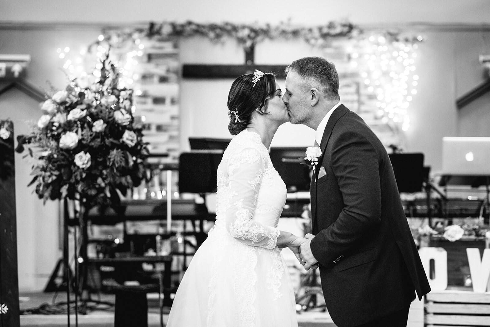 Bride and groom share a kiss at their wedding ceremony