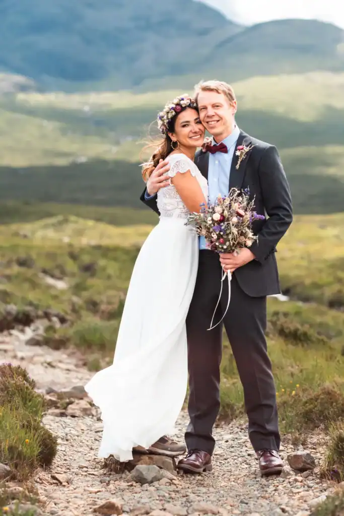 Couple embracing in on a scenic mountain path through the rugged Isle of Skye with a mountain backdrop