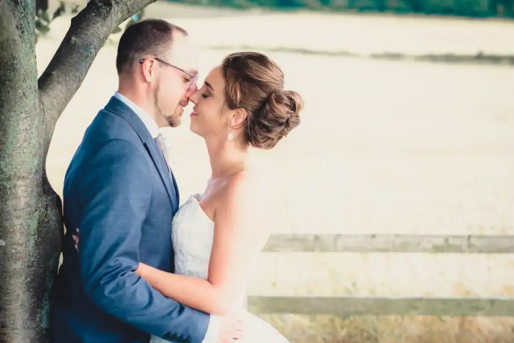 Bride and groom embrace under a tree in wedding photography at Roseberry Topping