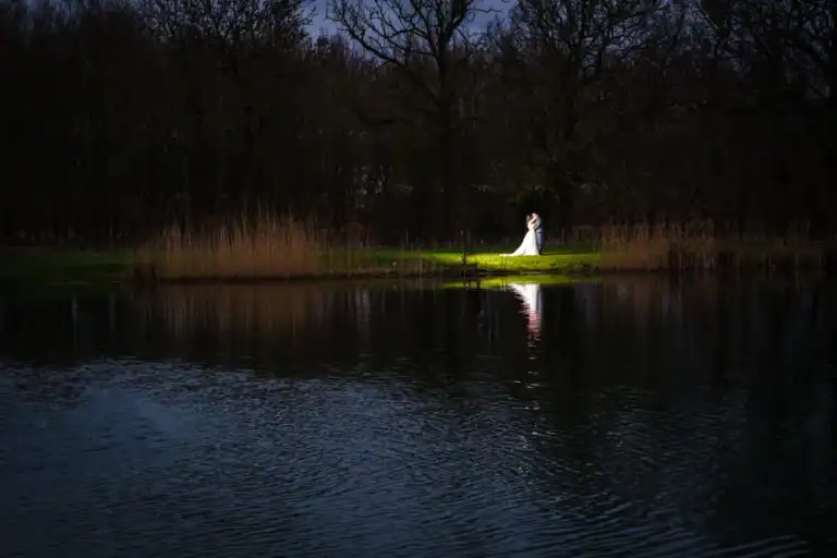 Bride and groom in spotlight reflecting on the lake at Silverwood Resort in Perth.