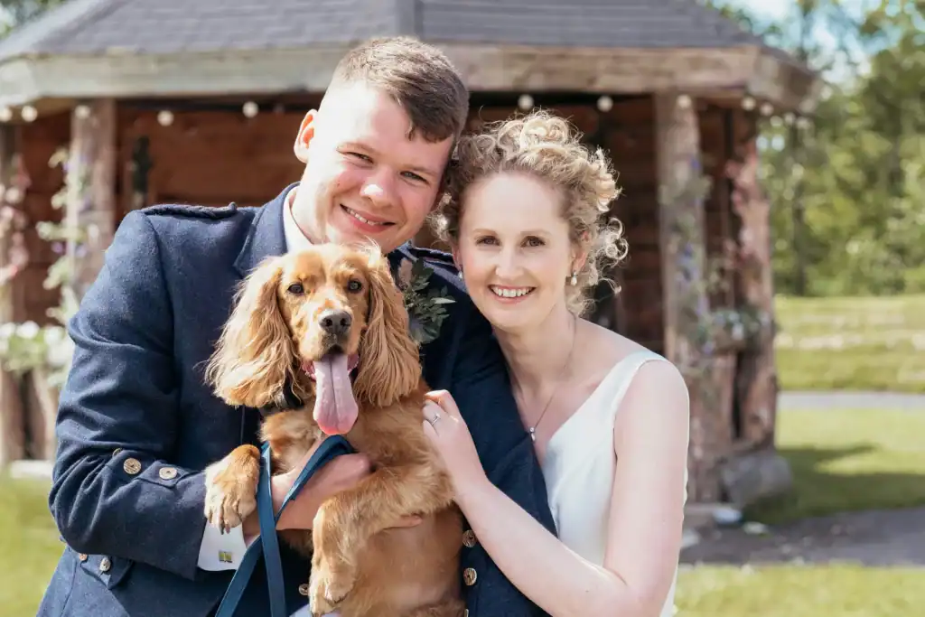 Bride and groom smiling with their dog at outdoor wedding at Silverwood Resort in Perth