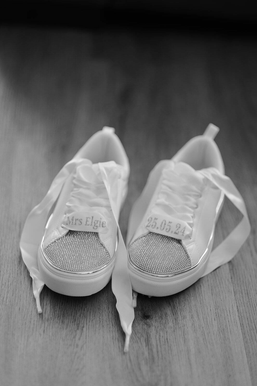 White bridal sneakers with rhinestones on wooden floor