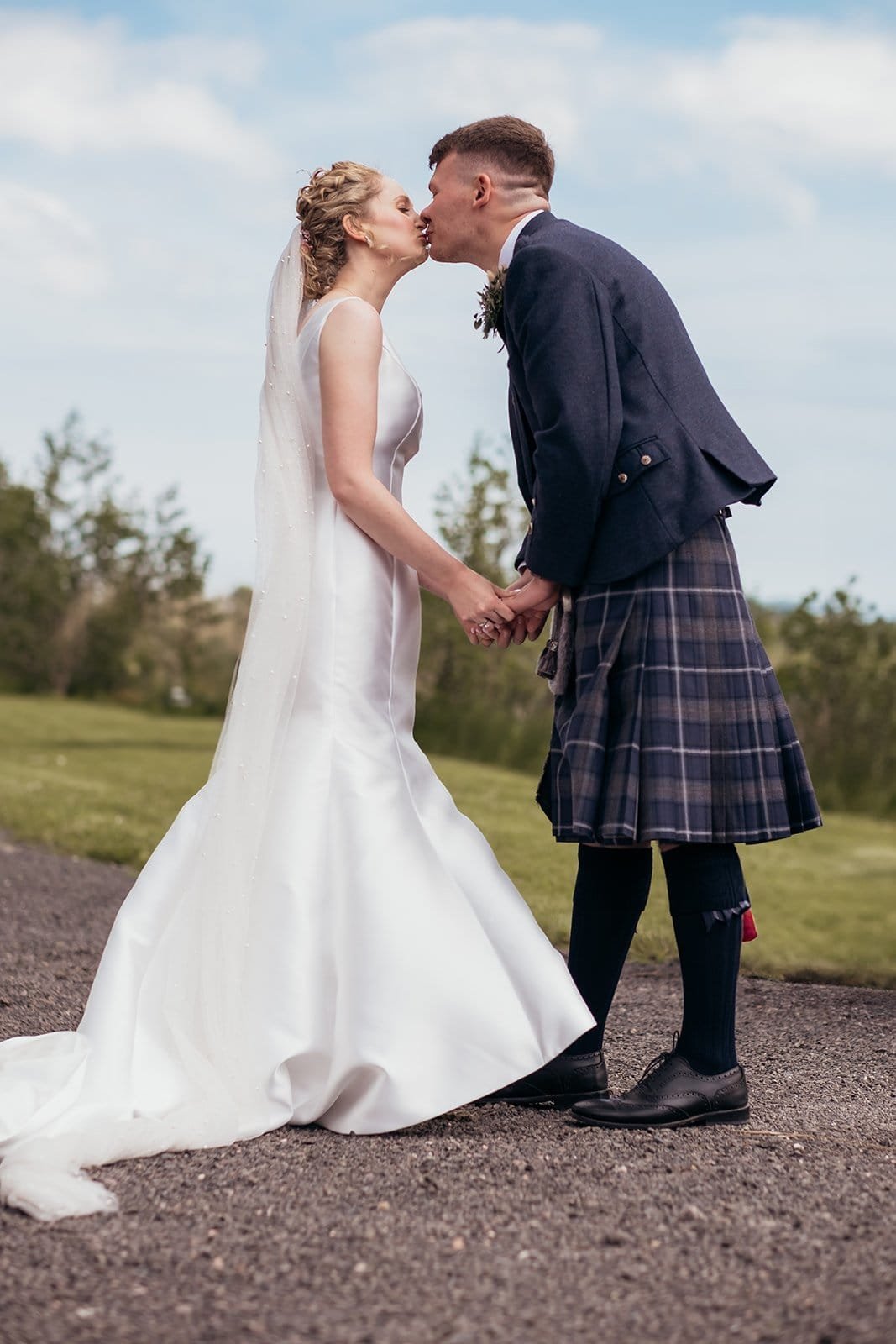 Bride and groom sharing a kiss at outdoor wedding ceremony