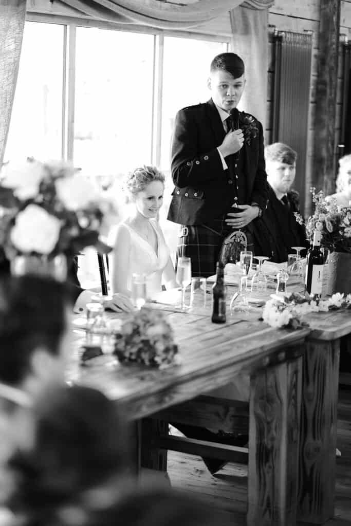 Groom giving a speech at a rustic wedding reception