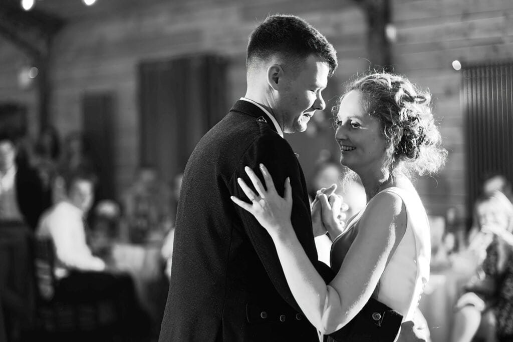 Couple sharing a romantic dance at a rustic wedding reception