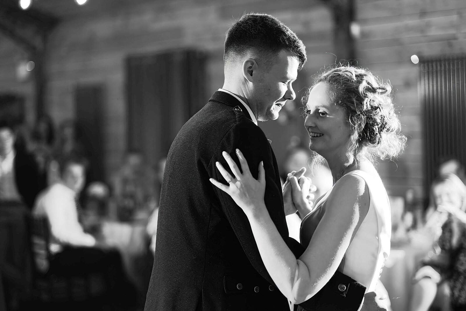 Couple sharing a romantic dance at a rustic wedding reception