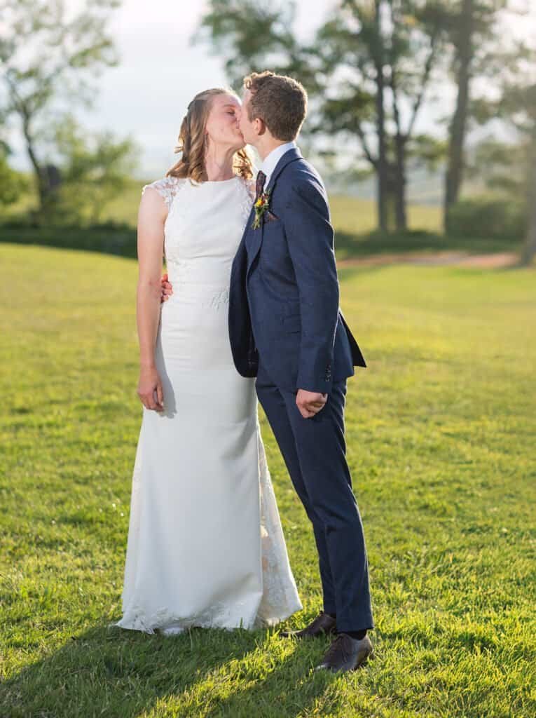 Bride and groom share a romantic kiss on a sunny day in Northumberland