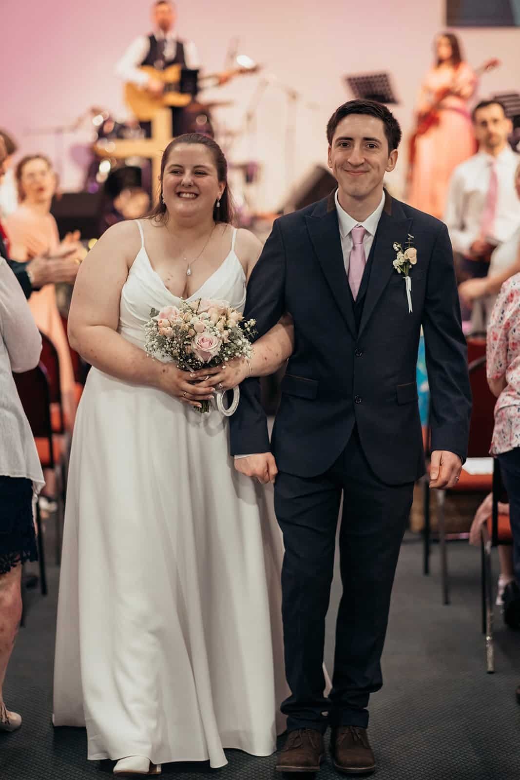 Bride and groom walking down the aisle at their wedding