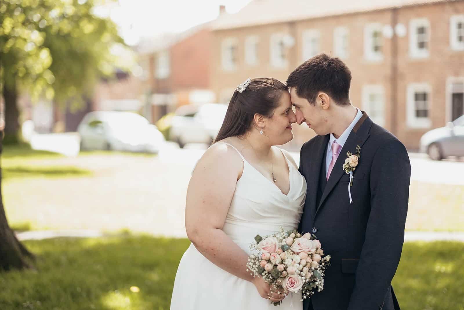 Bride and groom sharing a romantic moment in a park setting