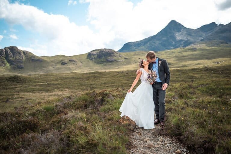 Bride and groom share a romantic kiss on their elopement in scenic mountains in Isle of Skye