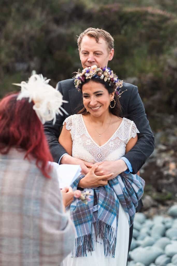 Bride and groom smiling during an outdoor wedding ceremony