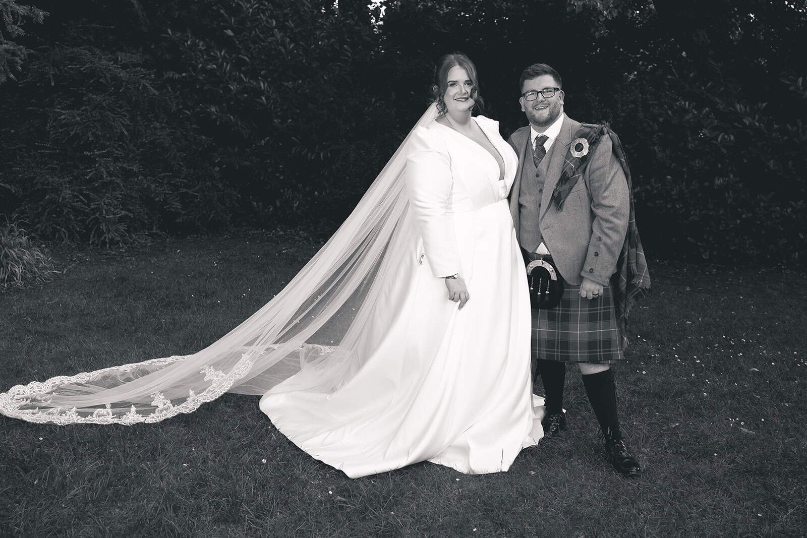 Bride and groom in wedding attire posing outdoors