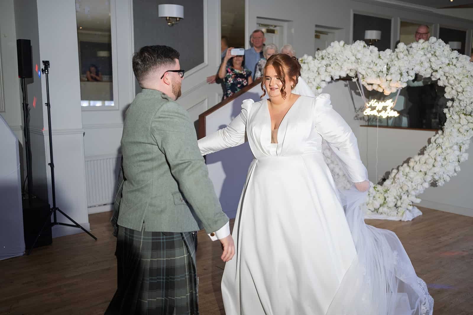 Bride and groom dancing joyfully at their wedding reception