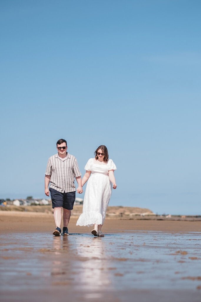 Couple enjoying a sunny walk on the beach together