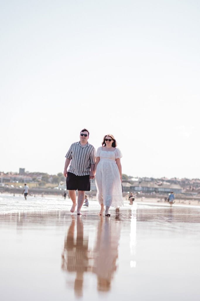 Couple walking on sunny Seaburn beach