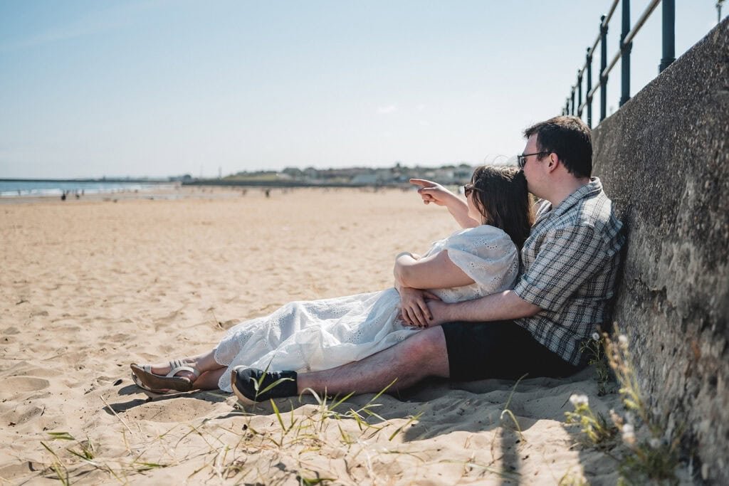 Couple relaxing on a sunny beach day with view of the ocean