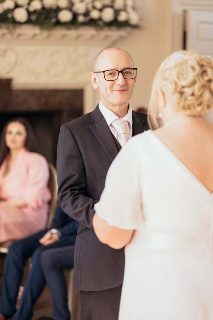 Wedding ceremony with couple exchanging vows indoors at Chatelherault