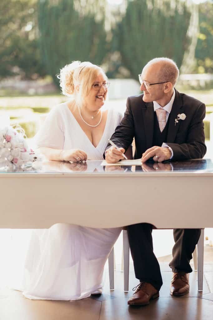 Happy couple signing wedding registry at outdoor ceremony