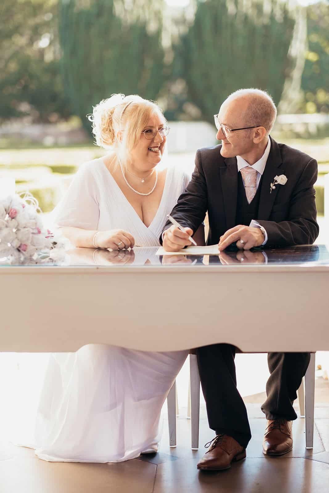 Happy couple signing wedding registry at outdoor ceremony