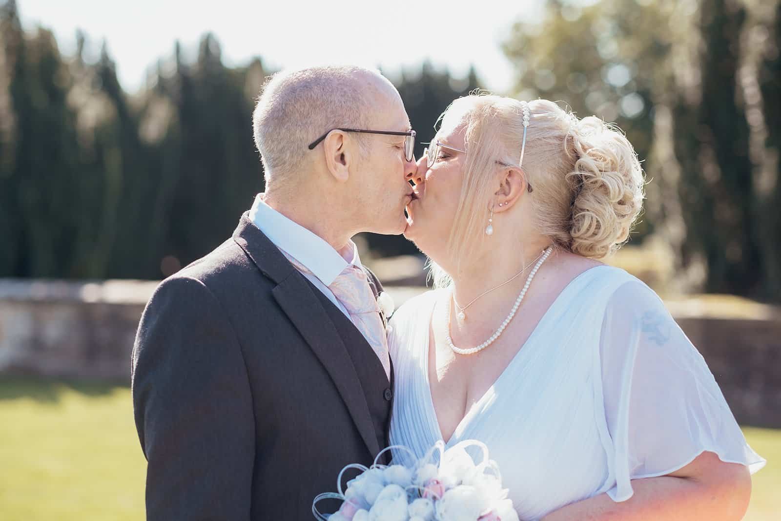 Elderly couple shares a loving kiss on their wedding day