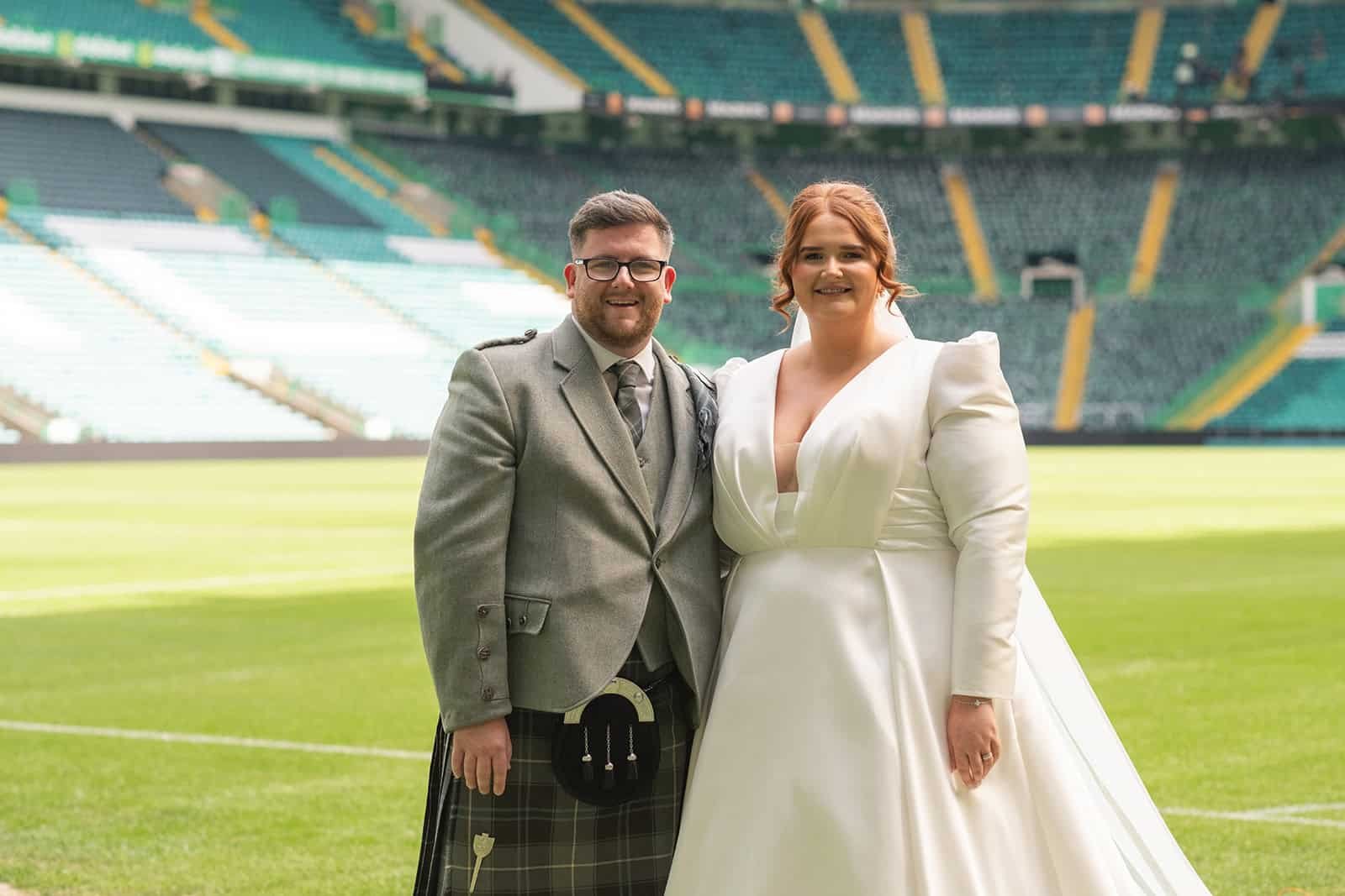 Couple in wedding attire pitch side at Celtic Park
