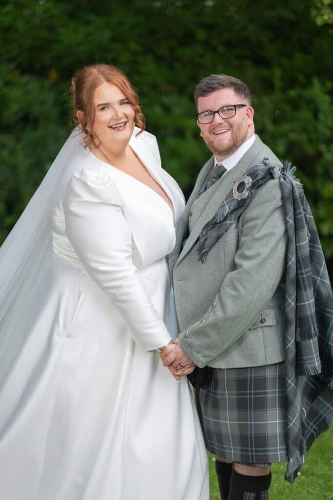 Bride and groom smiling on their wedding day outdoors