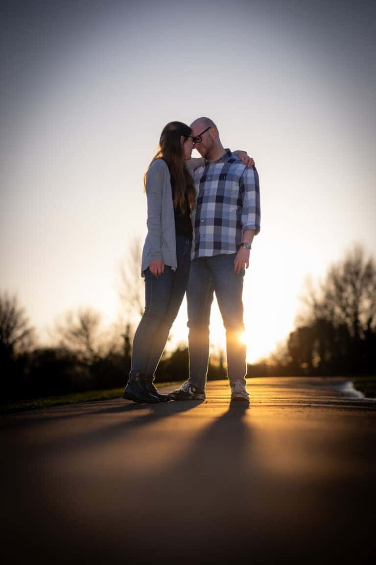 Couple embracing outdoors during sunset on their engagement photoshoot