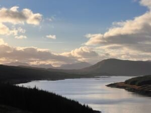 Scenic lake view with mountains under a cloudy blue sky