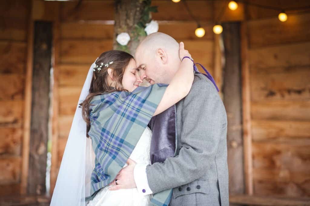 Bride and groom embrace in rustic wooden barn at Silverwood Resort Perth