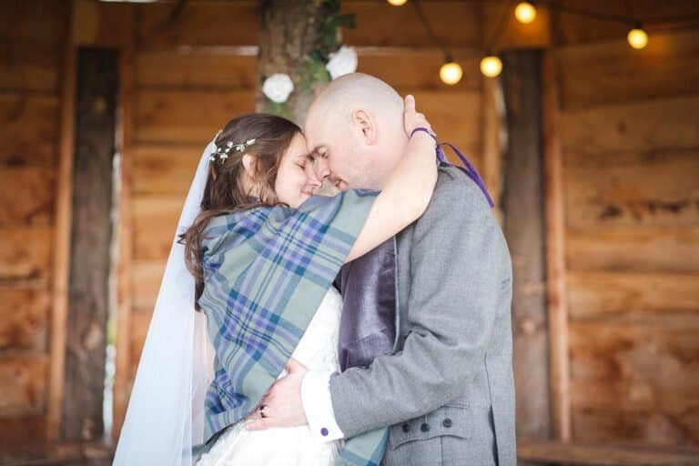 Bride and groom embrace in rustic wooden barn at Silverwood Resort Perth