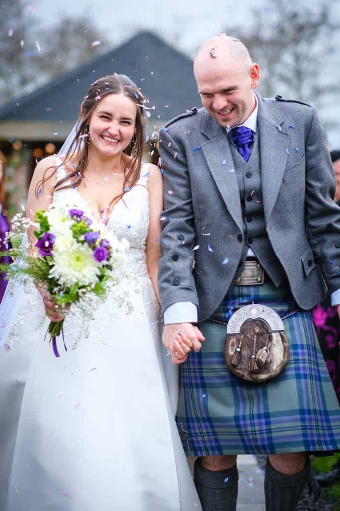 Bride and groom celebrating in traditional attire Scotland wedding photography