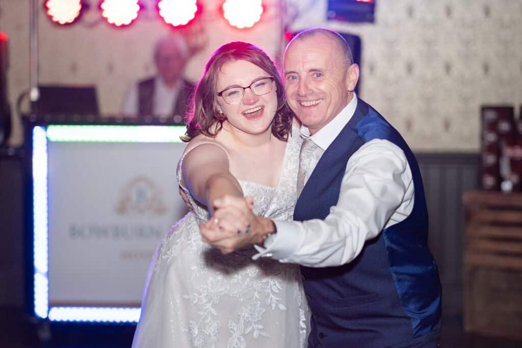 Couple enjoying a joyful dance at a lively wedding reception