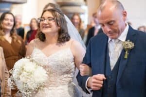 Bride walking down the aisle with her father at a wedding reception