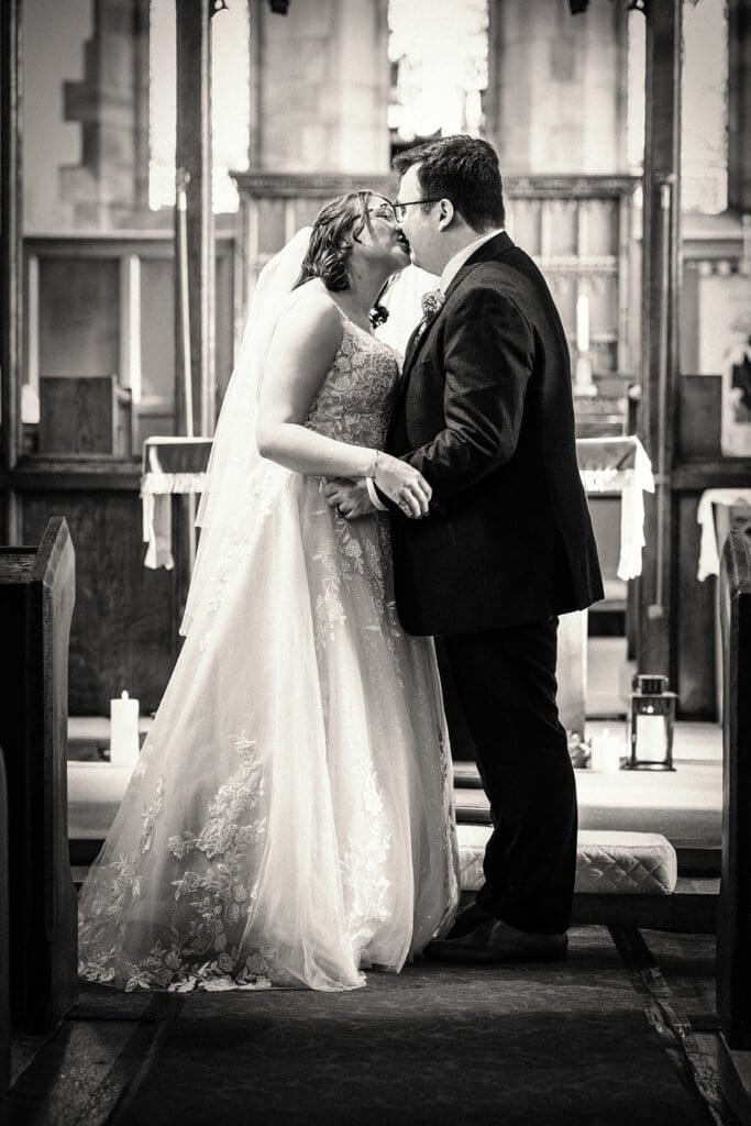 Wedding couple sharing a kiss in a beautiful church setting