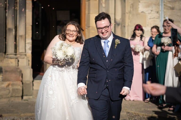 Bride and groom smiling at outdoor wedding ceremony exit