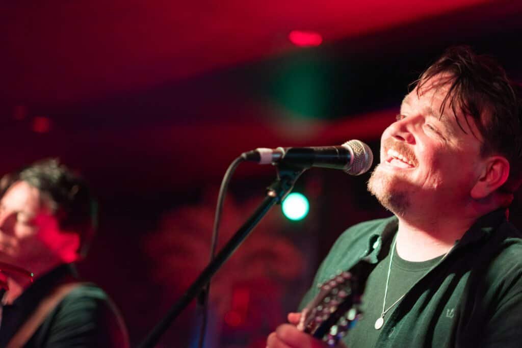 Singer passionately performing on stage under colorful lights