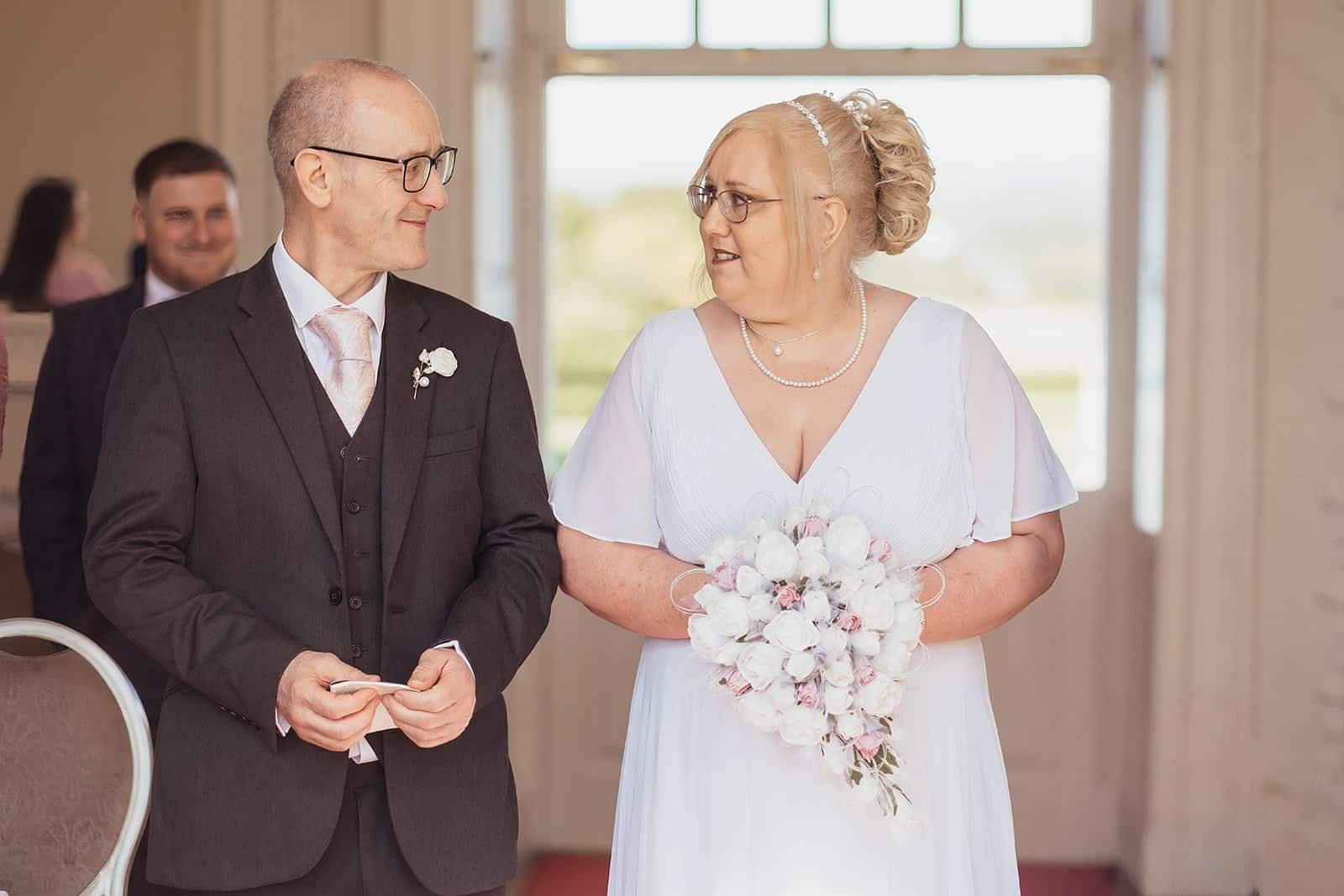 Bride and groom smiling during their wedding ceremony at Chatelherault