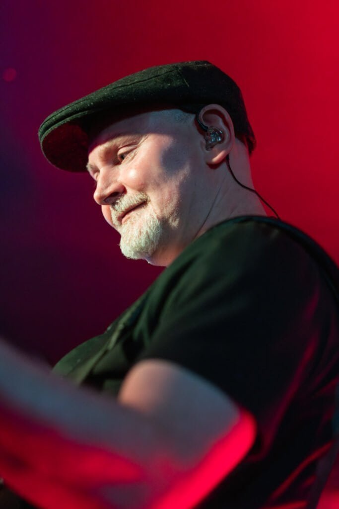 Man enjoying live music performance in a red-lit atmosphere