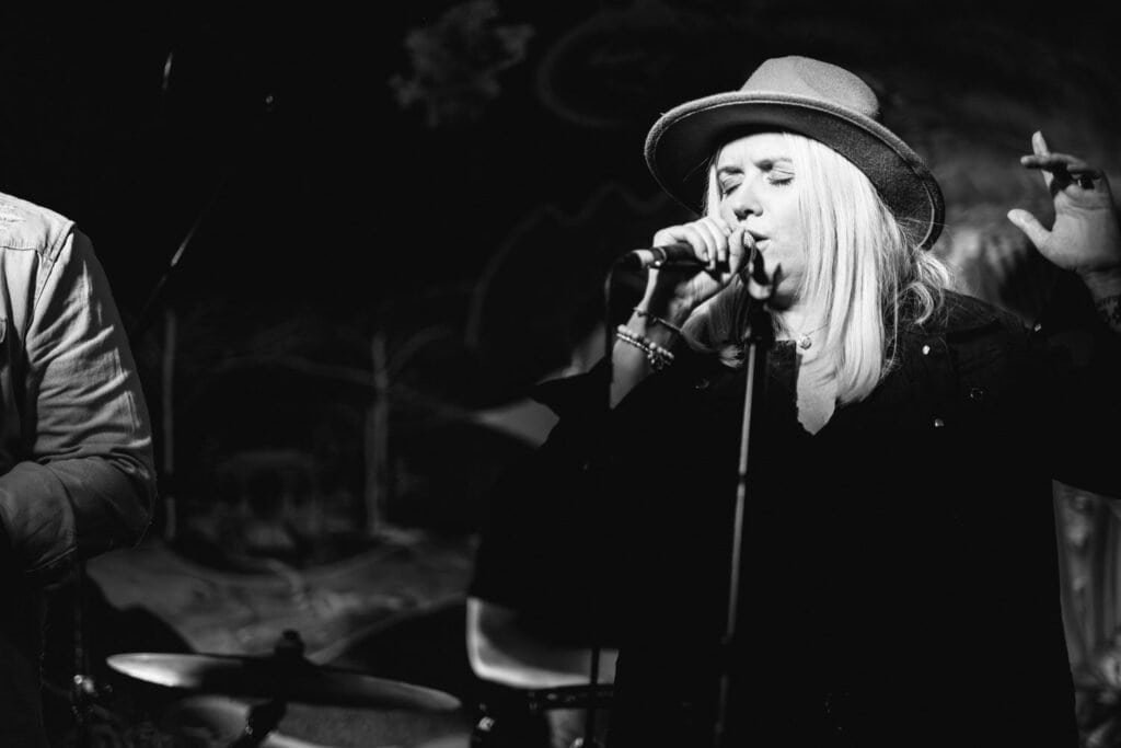 Musician performing passionately on stage in black and white