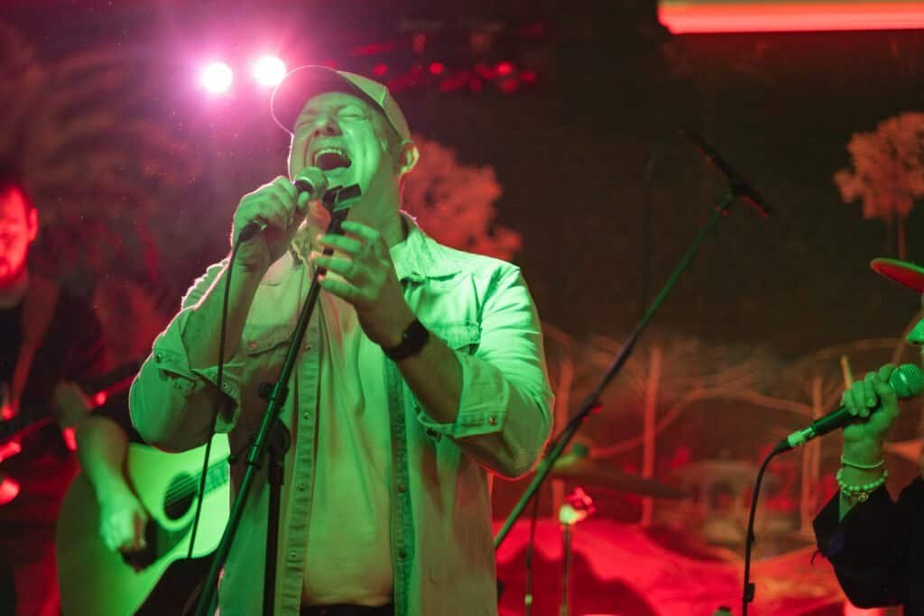 Singer passionately performing live on a vibrant stage