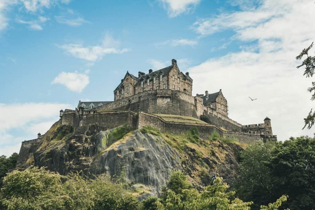 Edinburgh Castle perched on its rock, seen from below against a blue sky