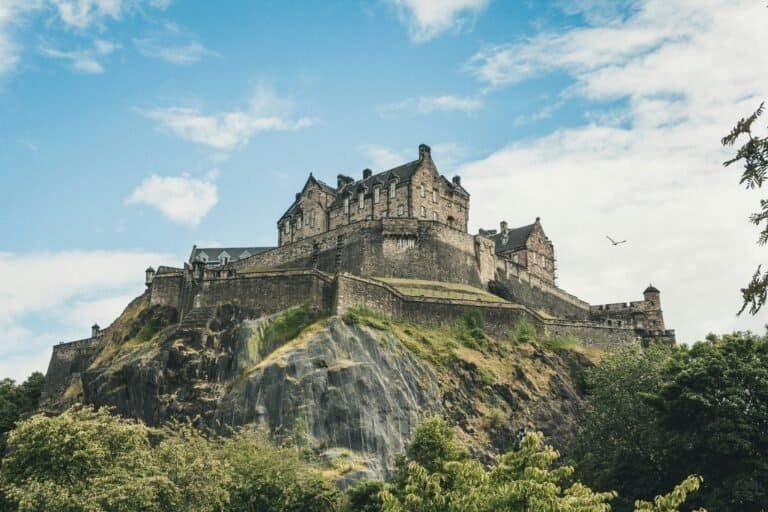 Edinburgh Castle perched on its rock, seen from below against a blue sky