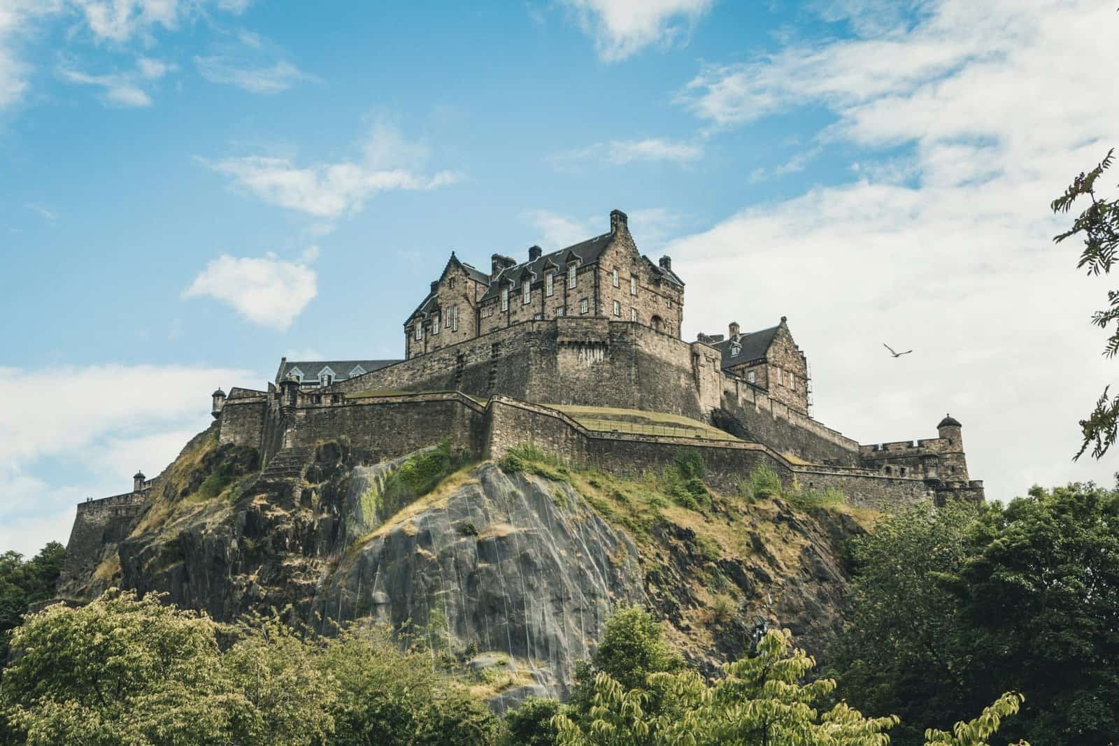 Edinburgh Castle perched on its rock, seen from below against a blue sky